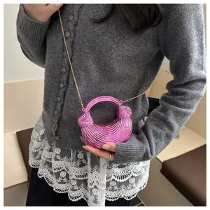 Dettaglio della borsa a tracolla plissettata rosa metallizzato con manico rotondo
