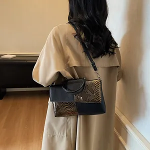 Sac à main élégant motif crocodile avec épissage géométrique et poignée ronde