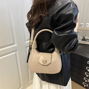 Minimalist beige glossy patent leather shoulder bag with saddle shape for women