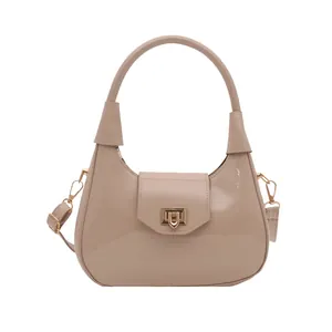Glossy beige patent leather hobo bag with gold hardware and versatile crossbody strap