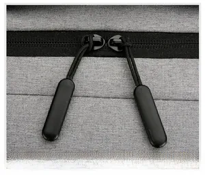 Detail view of smooth double metal zippers on durable grey oxford fabric business backpack