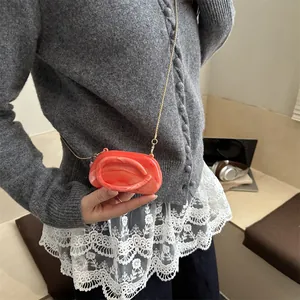Mini orange marble shell clutch bag with gold chain strap shown on crossbody model