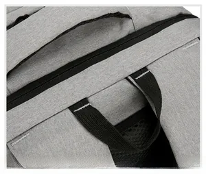 Macro detail of the reinforced top handle and zipper stitching on this grey business backpack