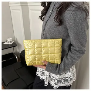 Detail of yellow quilted padded makeup bag showing square stitch pattern and fluffy texture
