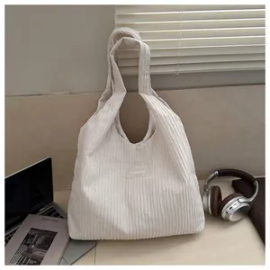 Chic beige corduroy tote bag with vertical stripes and fashion label in a home office setting
