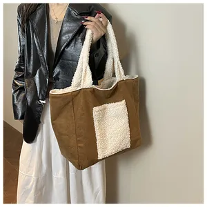 Detail of the brown canvas tote bag featuring white faux shearling trim and patchwork pocket