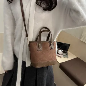 Sac seau matelassé marron avec bandoulière présenté dans une photo lifestyle élégante