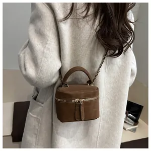 Achteraanzicht van een donkerbruine matte mini-crossbody emmertas gedragen door een model