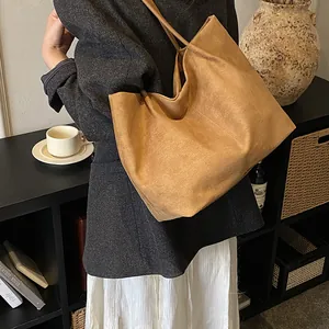Minimalist large brown suede tote bag for women shown as a stylish shoulder bag on a model