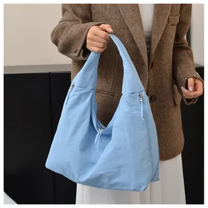 Close-up of light blue large capacity hobo bag showing nylon texture and side zipper detail