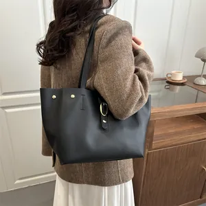 Large black matte leather tote bag for women with minimalist shoulder straps and gold studs