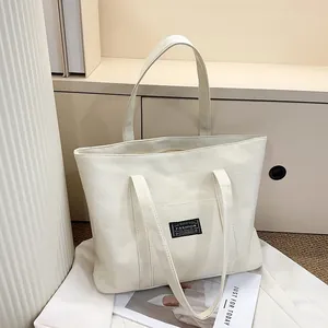 Vue détaillée du sac cabas en lin crème avec texture en tissu robuste et étiquette de mode