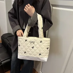 White quilted tote bag with black bow embroidery and metallic bow clasp for women