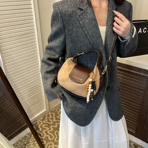 Women's crescent shoulder bag in camel suede with leather trim and beaded tassel detail