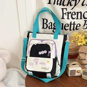 Detail of color-block canvas tote bag with Happy Days patch and mesh pocket