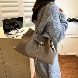 Retro coffee matte leather tote bag with bead charm shown in a minimalist home setting
