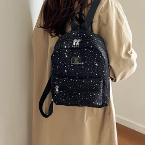Women's black star pattern backpack featuring a large main pocket and nylon straps