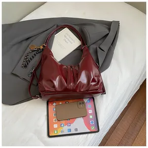 Grand sac cabas en cuir verni bordeaux montrant sa capacité avec tablette et livres