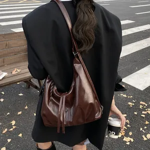 Sac à bandoulière hobo vintage en cuir marron foncé dans une scène de rue urbaine