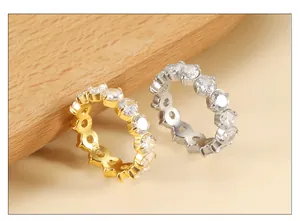 Close-up of gold and silver eternity rings with round-cut cubic zirconia on wood
