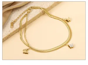 Detail der 18k vergoldeten Schicht-Fußkette mit Schmetterlingsanhängern und Schlangenkette