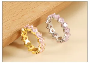 Detailed macro view of gold and silver eternity rings with pink round-cut cubic zirconia