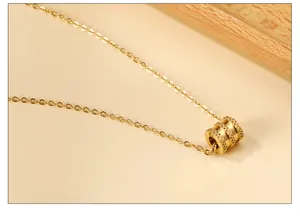 Κοντινό πλάνο κολιέ από ανοξείδωτο ατσάλι 18k με ανάγλυφο κυλινδρικό μενταγιόν