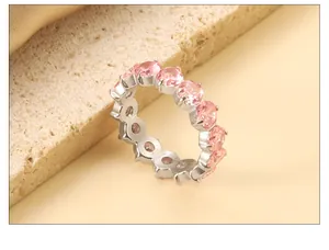 Macro side view of silver stainless steel eternity ring with pink cubic zirconia stones