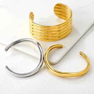 Set de tres pulseras abiertas geométricas de acero inoxidable pulido en color oro y plata