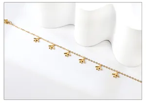 Detailaufnahme des minimalistischen 18k Gold-Fußkettchens mit kleinen Flugzeug-Anhängern
