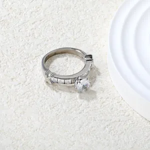 Détail macro d'une bague argentée à quatre griffes avec zircon et pierres latérales