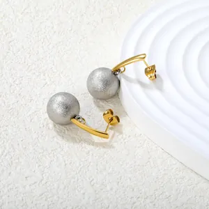 Detail van tweekleurige goud en zilver gedraaide ovale oorbellen op wit display