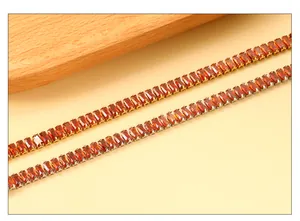 Detalle de pulsera tennis bañada en oro de 18k con circonitas rectangulares de color naranja
