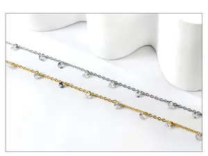 Detail of 18k gold and silver plated cross chain with small round clear crystal charms