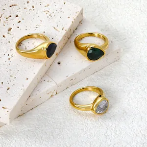 Detailed view of water drop gemstone rings in gold plating on travertine stone