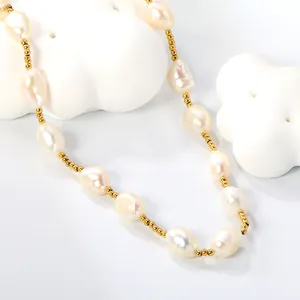 Elegante collar de perlas de agua dulce con cuentas doradas sobre fondo blanco minimalista