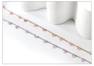 Detail view of 18k gold and silver plated chains with pink zircon pendants on a white base