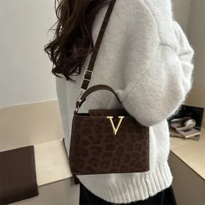Fashionable leopard print shoulder bag with gold V buckle and adjustable strap