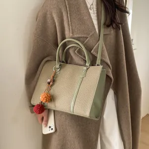 Minimalist large sage green and khaki woven tote bag with a decorative plush pom-pom charm