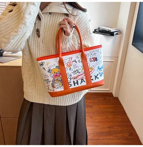 Detailansicht der Canvas-Tasche mit bunten Graffiti und hellen orangefarbenen Ledergriffen