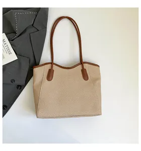 Macro detail of beige woven tote bag texture with brown leather straps and trim