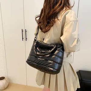 Glossy black quilted down shoulder bag for women with adjustable strap on model