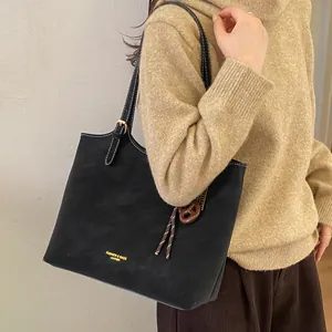 Grand sac cabas noir rétro avec surpiqûres blanches porté par un mannequin