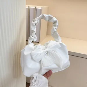Détail du sac à main blanc crème avec grand nœud et poignée froncée pour femme