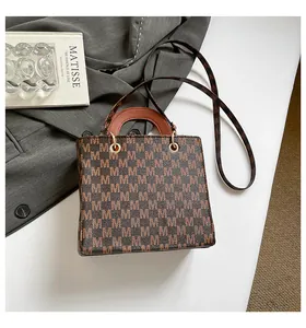 Vue de dessus d'un sac à main marron avec logo et détails dorés sur un fond élégant