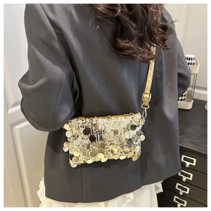 Detail of trendy sequins crossbody bag with gold and silver metallic discs on female model