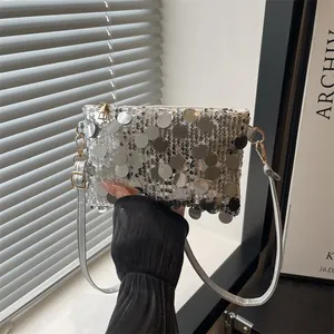 Detail of silver sequin shoulder bag with large reflective scales and gold metal buckle