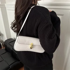 White crocodile pattern baguette bag with gold buckle worn by model on black sweater
