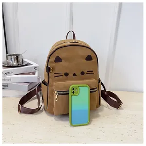 Detail of a brown cat embroidery backpack with side pocket and a smartphone for scale