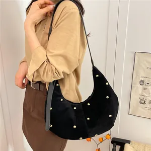 Large black hobo tote bag with gold rivet detailing and crescent shape for women